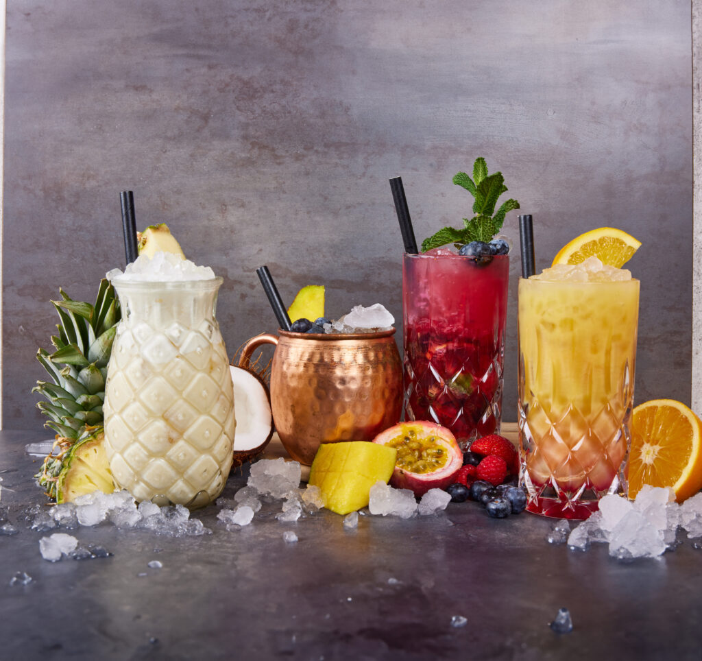 Ein weißer, ein roter und ein gelber Cocktail mit Eiswürfern.
